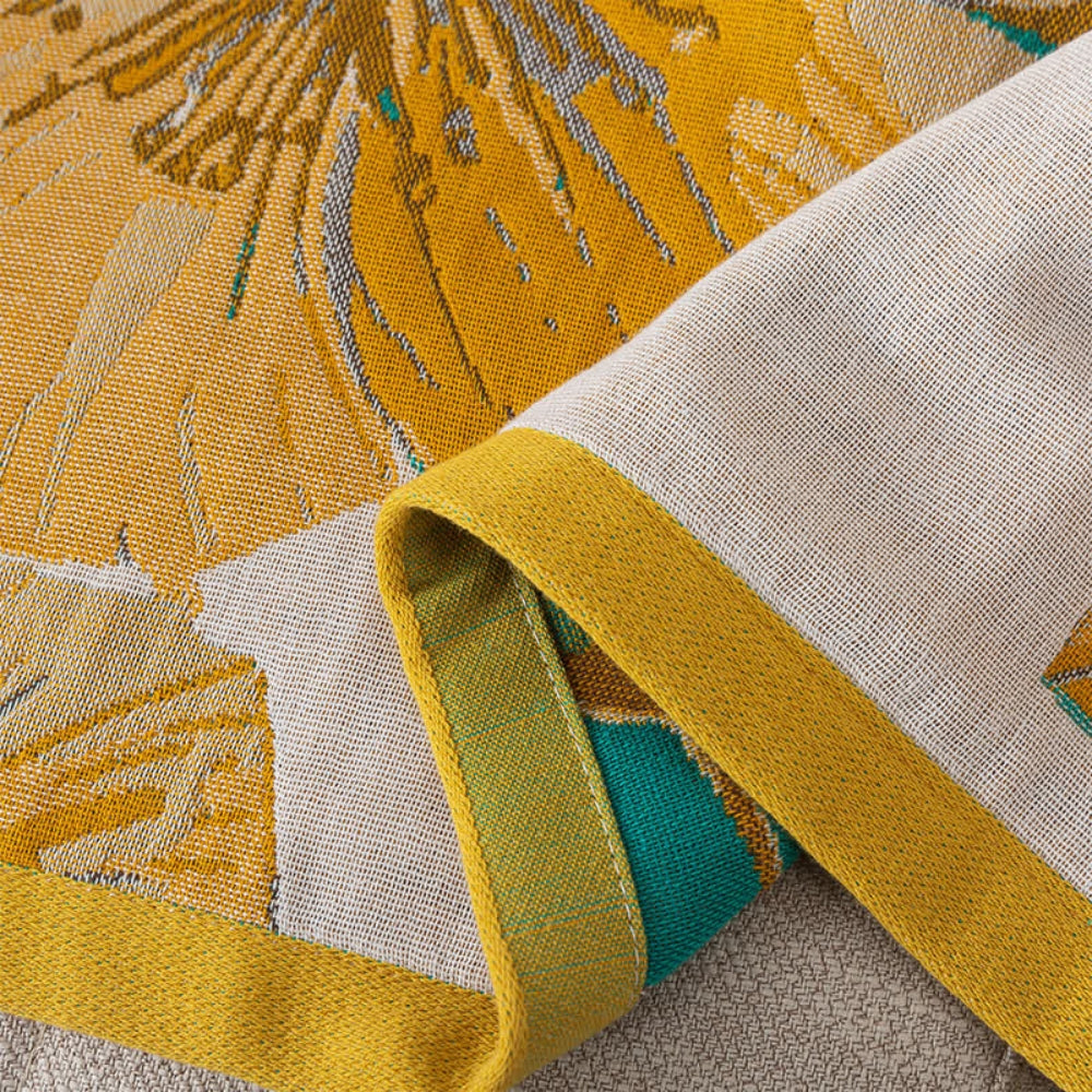 Floral throw blanket with yellow flower and green leaf design on white background, soft decorative sofa and bed cover