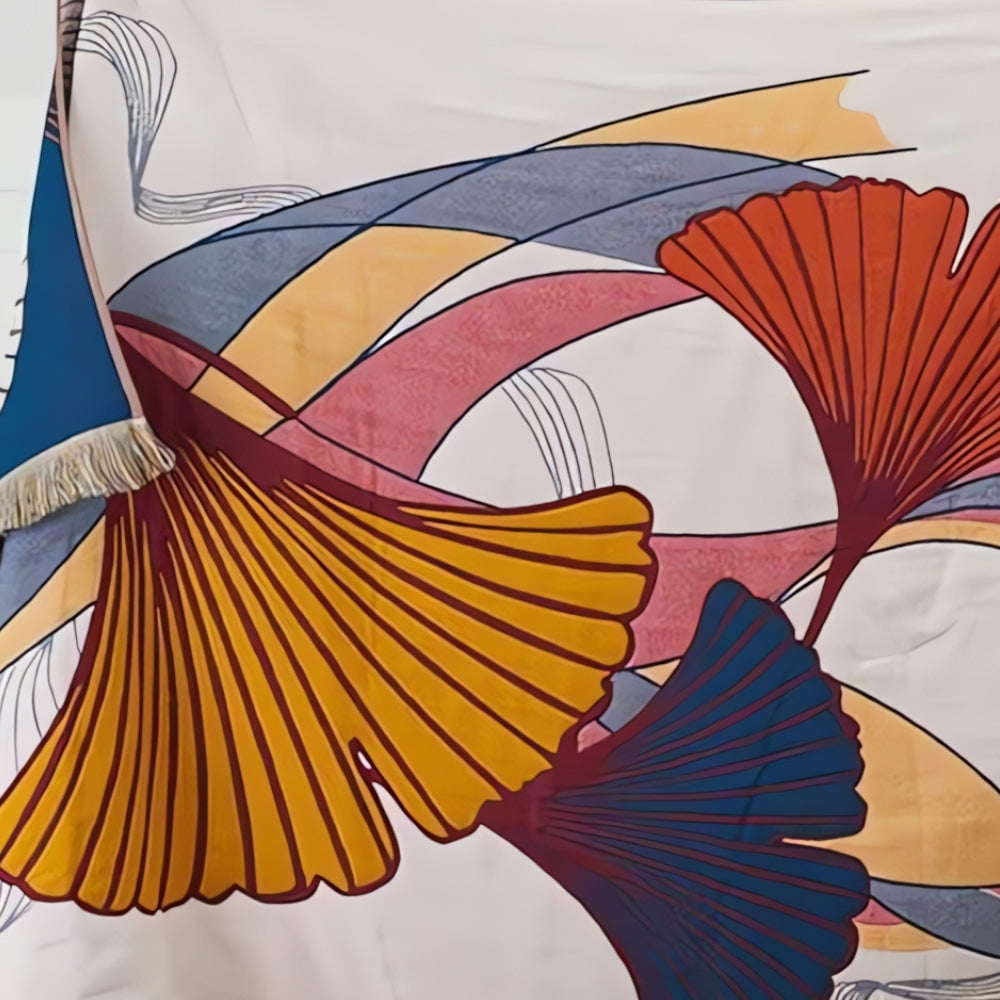 Soft decorative throw blanket with bold abstract ginkgo leaf pattern in orange, blue, and yellow, finished with tassel edges