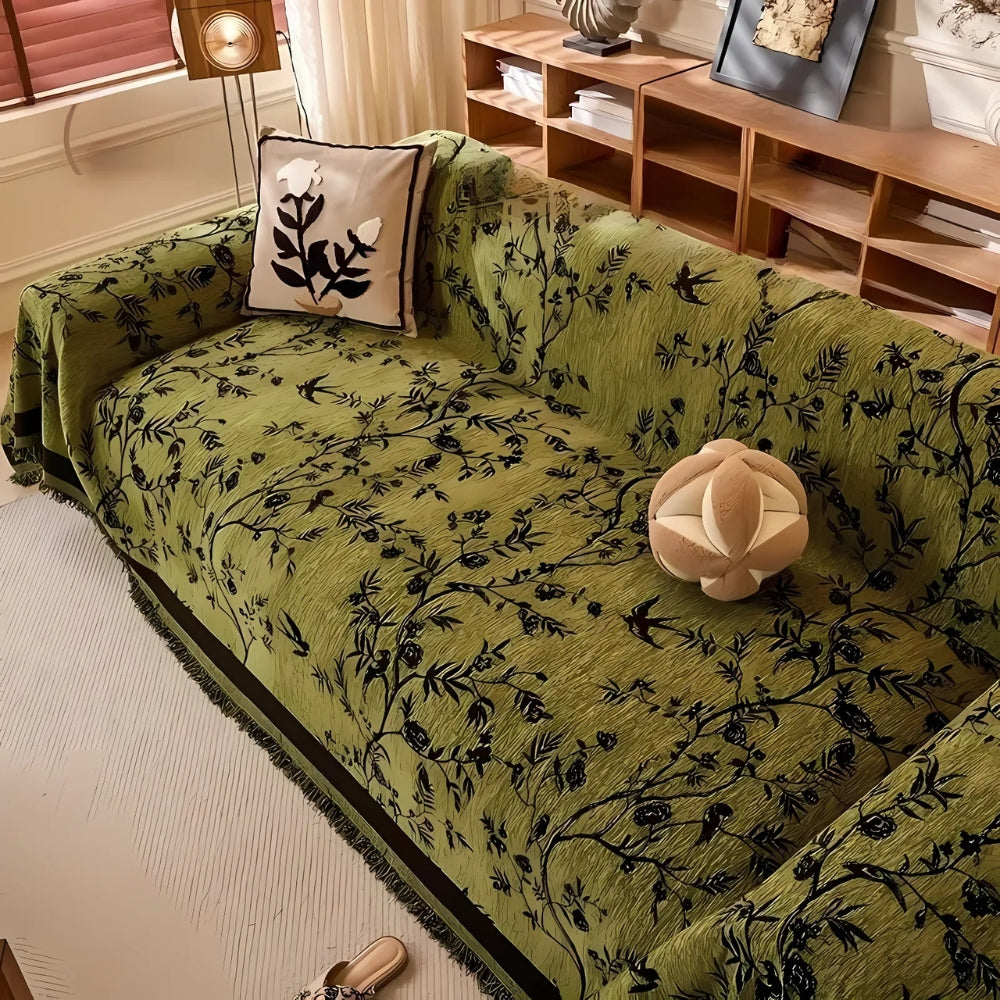 Green sofa cover with black floral pattern and fringed edges, decorative couch protector for living room