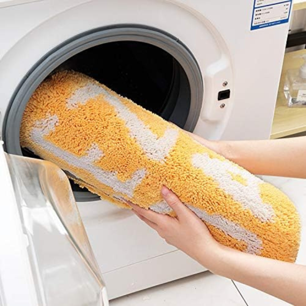 Yellow lemon-shaped bathroom rug with white text ‘Squeeze the Day’, soft absorbent bath mat