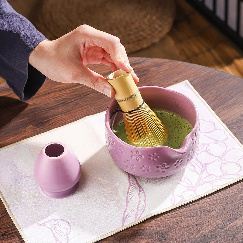 Japanese matcha tea whisk with purple cherry blossom bowl, traditional bamboo chasen for green tea ceremony