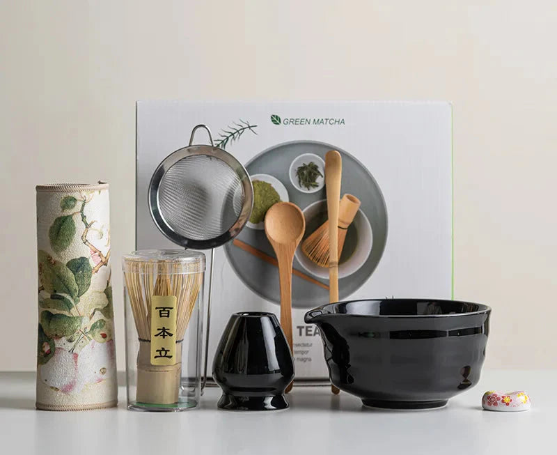 Japanese matcha set with white ceramic tea bowl and pink cherry blossom design, bamboo whisk, sifter, and tea scoop for traditional tea ceremony