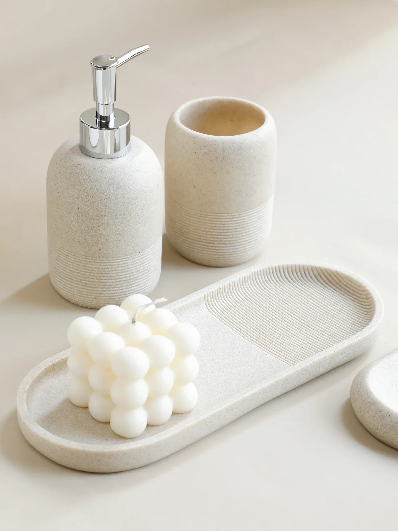 Minimalist ceramic bathroom accessory set with soap dispenser, toothbrush holder, and soap dish for modern home decor