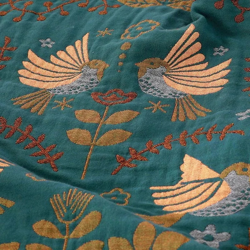 Bohemian sofa throw blanket with teal background, bird and floral patterns, and fringe edges, decorative couch cover for living room