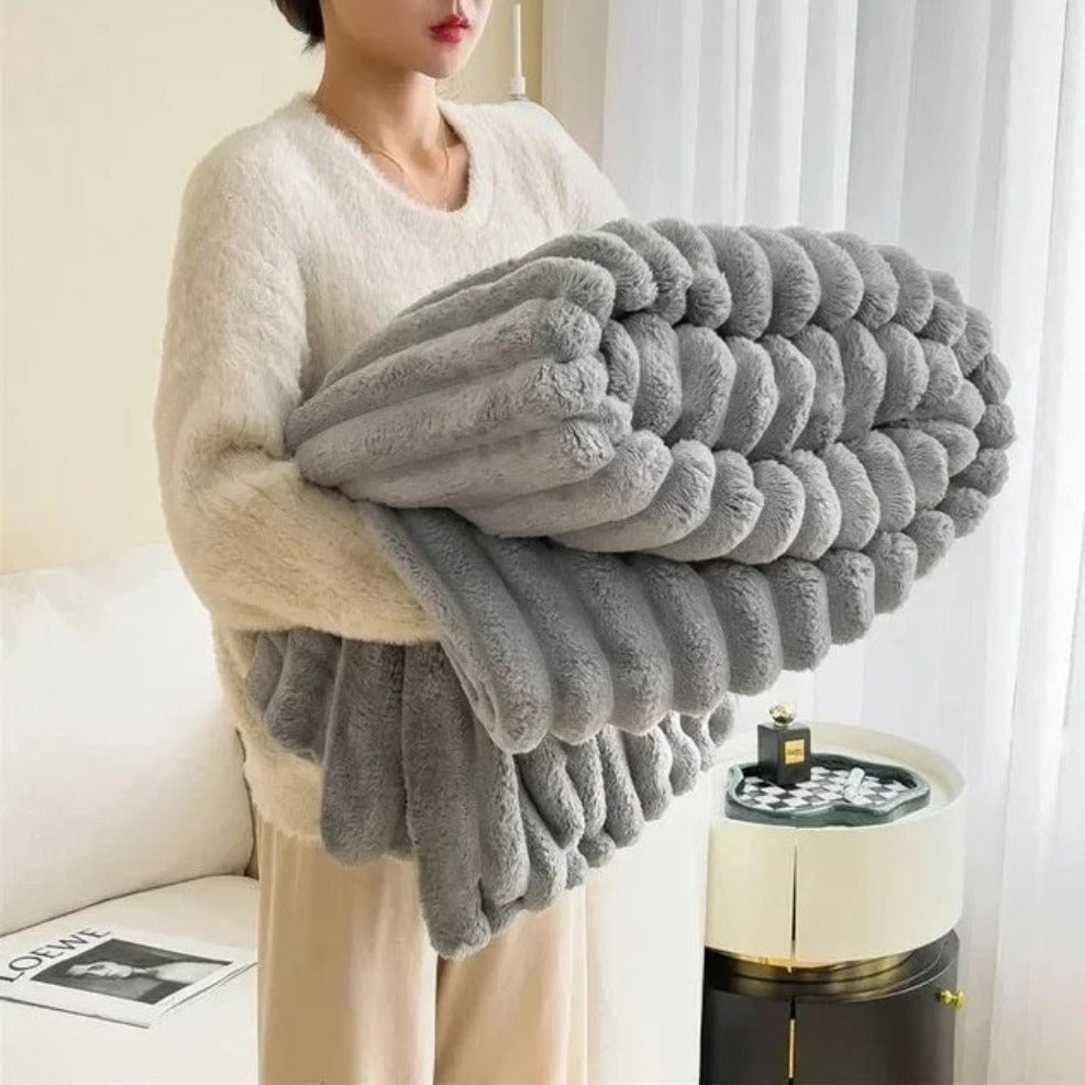 Plush grey faux fur throw blanket with ribbed texture, soft and warm decorative couch or bed cover