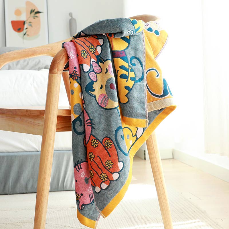 Colorful kids blanket with cartoon cat design in orange, yellow, and blue, soft cotton throw for bedroom or nursery