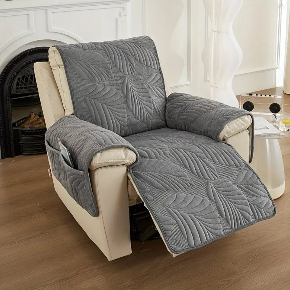 Grey quilted recliner chair cover with leaf pattern, soft padded armrest protectors and side storage pocket for living room furniture protection