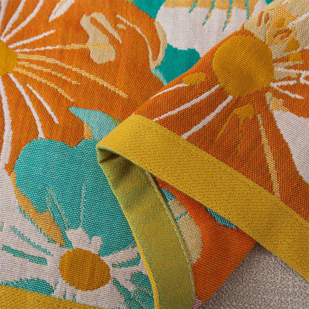 Floral throw blanket with white and orange flower design on teal background, soft decorative sofa and bed cover