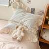 Pastel pink gingham ruffle bedding set with cream frilled edges, soft cotton duvet cover and pillowcases in romantic shabby chic bedroom decor