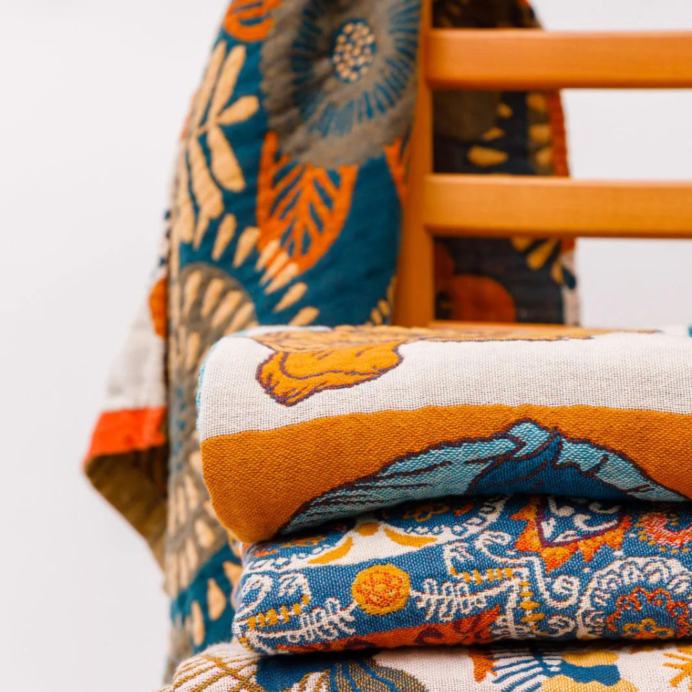 Reversible beach towel with tropical floral pattern in vibrant blue, orange, and green, quick-dry cotton for pool or seaside