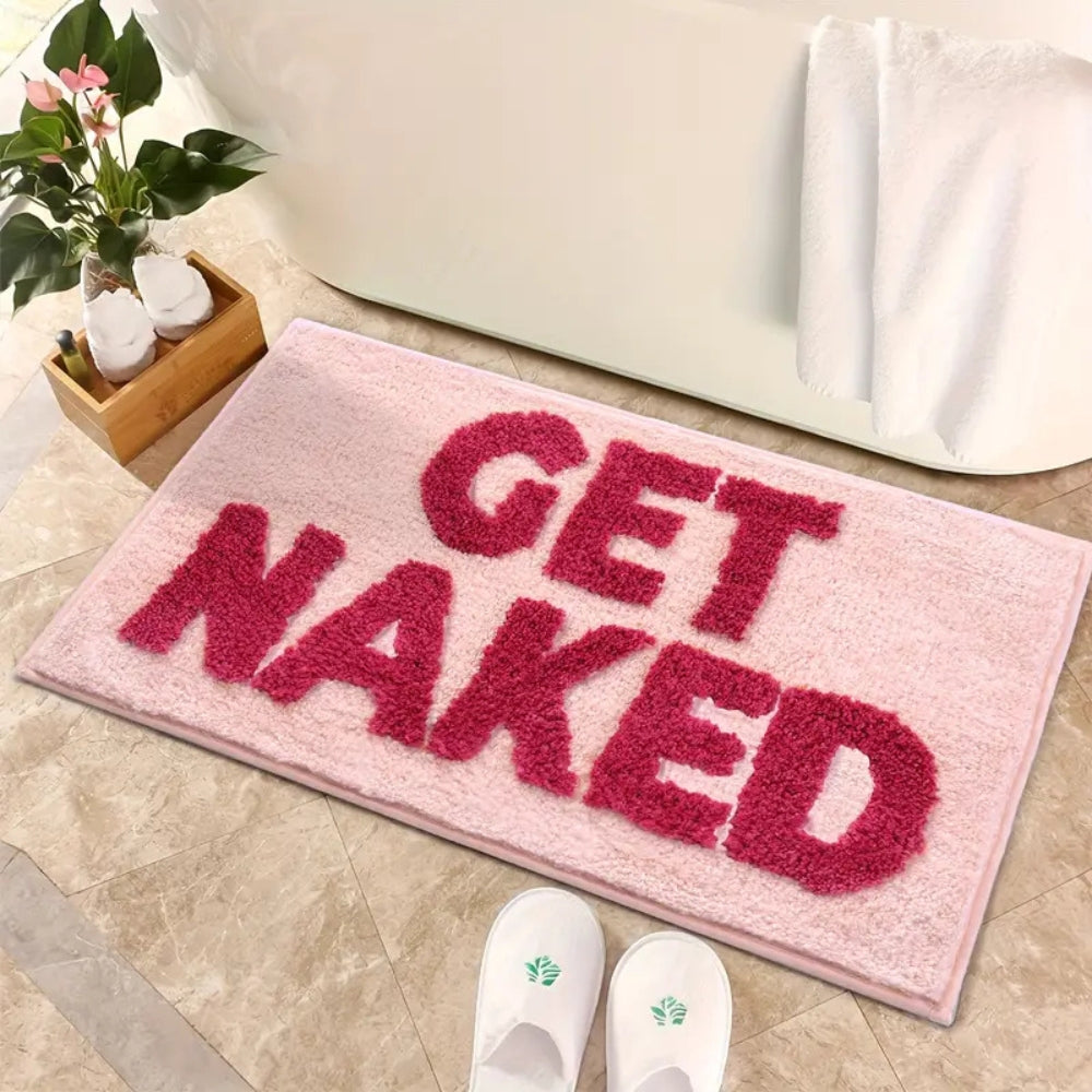 Pink bath mat with bold red ‘Get Naked’ lettering, soft absorbent funny bathroom rug for modern decor