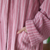 Soft pink terry bathrobe with white stripes and wide sleeves, cozy absorbent loungewear