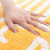 Yellow lemon-shaped bathroom rug with white text ‘Squeeze the Day’, soft absorbent bath mat
