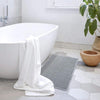 Anti-slip waffle bathroom rug in natural beige with textured weave, absorbent bath mat for shower and bathroom floor