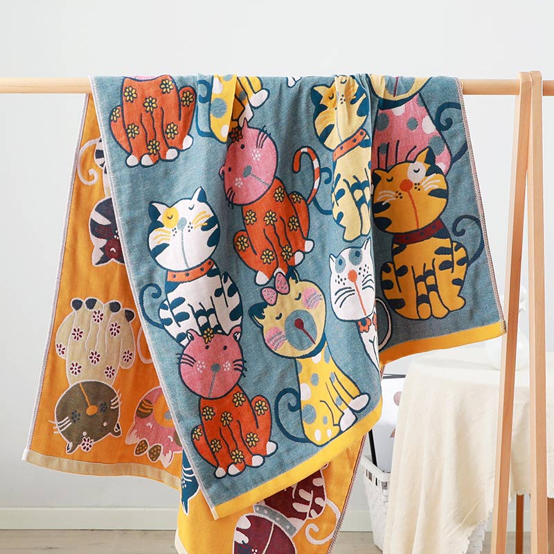 Colorful kids blanket with cartoon cat design in orange, yellow, and blue, soft cotton throw for bedroom or nursery