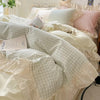 Pastel pink gingham ruffle bedding set with cream frilled edges, soft cotton duvet cover and pillowcases in romantic shabby chic bedroom decor