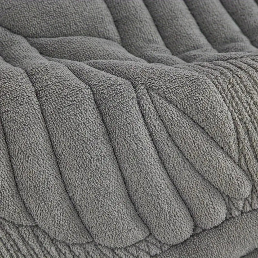 Grey quilted recliner chair cover with leaf pattern, soft padded armrest protectors and side storage pocket for living room furniture protection