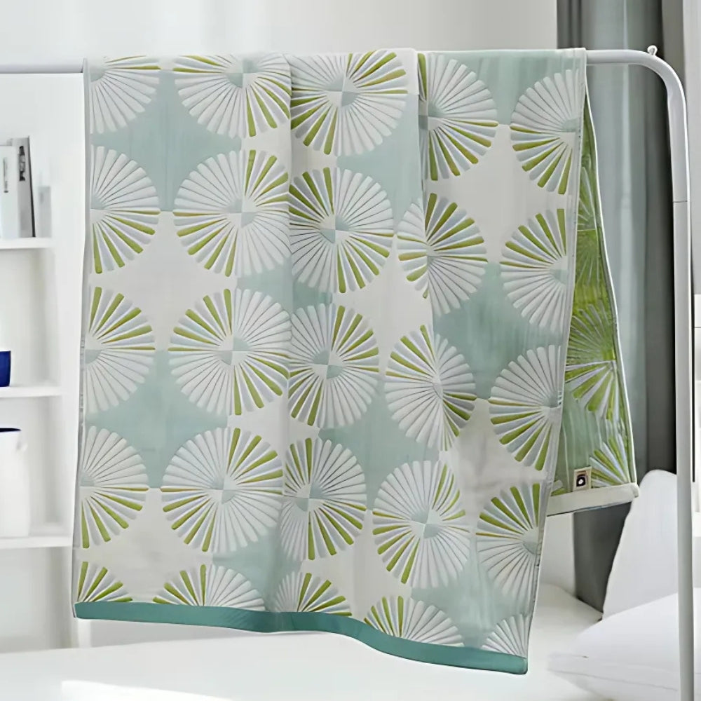 Light green and white throw blanket with modern fan circle pattern, soft decorative accent for sofa or bed