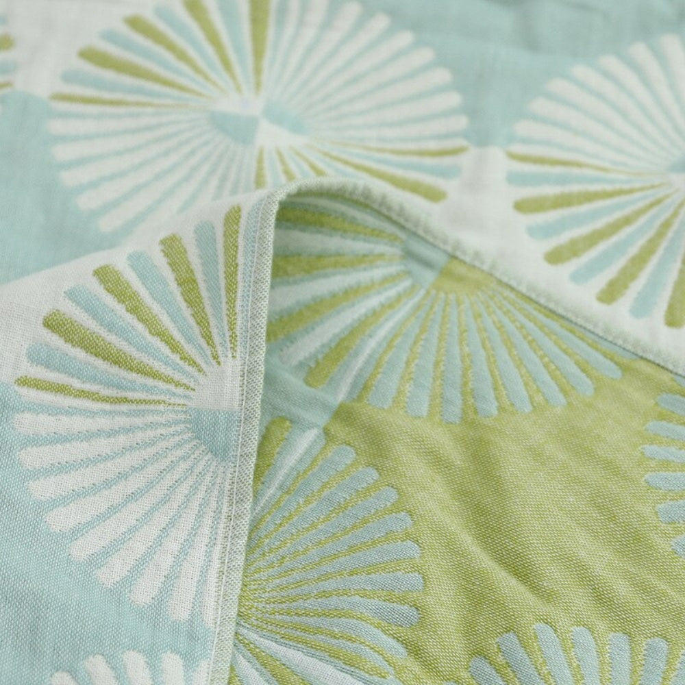 Light green and white throw blanket with modern fan circle pattern, soft decorative accent for sofa or bed