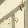 Handmade macrame leaf garland wall hanging with natural cotton rope and wooden beads for boho home decor