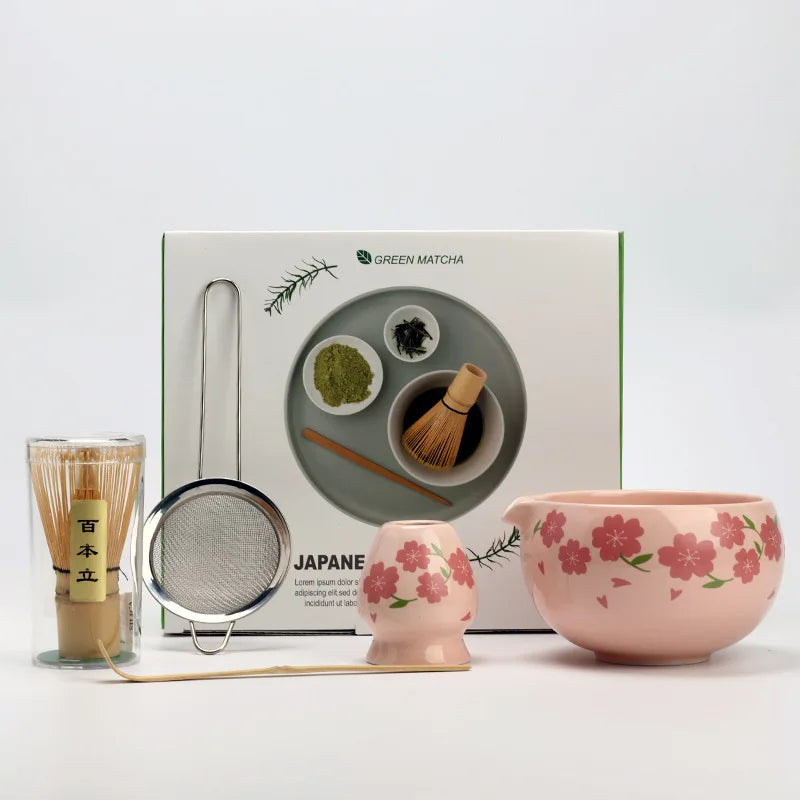 Japanese matcha tea set with pink cherry blossom bowl, bamboo whisk, sifter, and spoon for traditional green tea ceremony