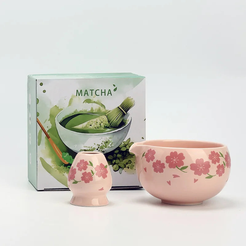 Japanese matcha tea set with pink cherry blossom bowl, bamboo whisk, sifter, and spoon for traditional green tea ceremony