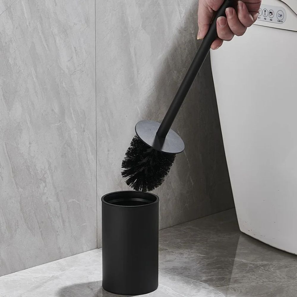 Gold toilet brush with black bristles and matching holder, modern stainless steel bathroom cleaning set
