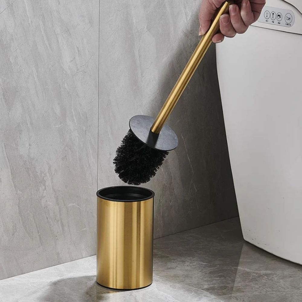 Gold toilet brush with black bristles and matching holder, modern stainless steel bathroom cleaning set