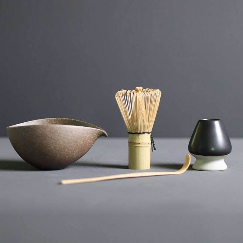 Minimalist Japanese matcha set with black ceramic tea bowl, bamboo whisk, whisk holder, and bamboo tea scoop for authentic tea ceremony