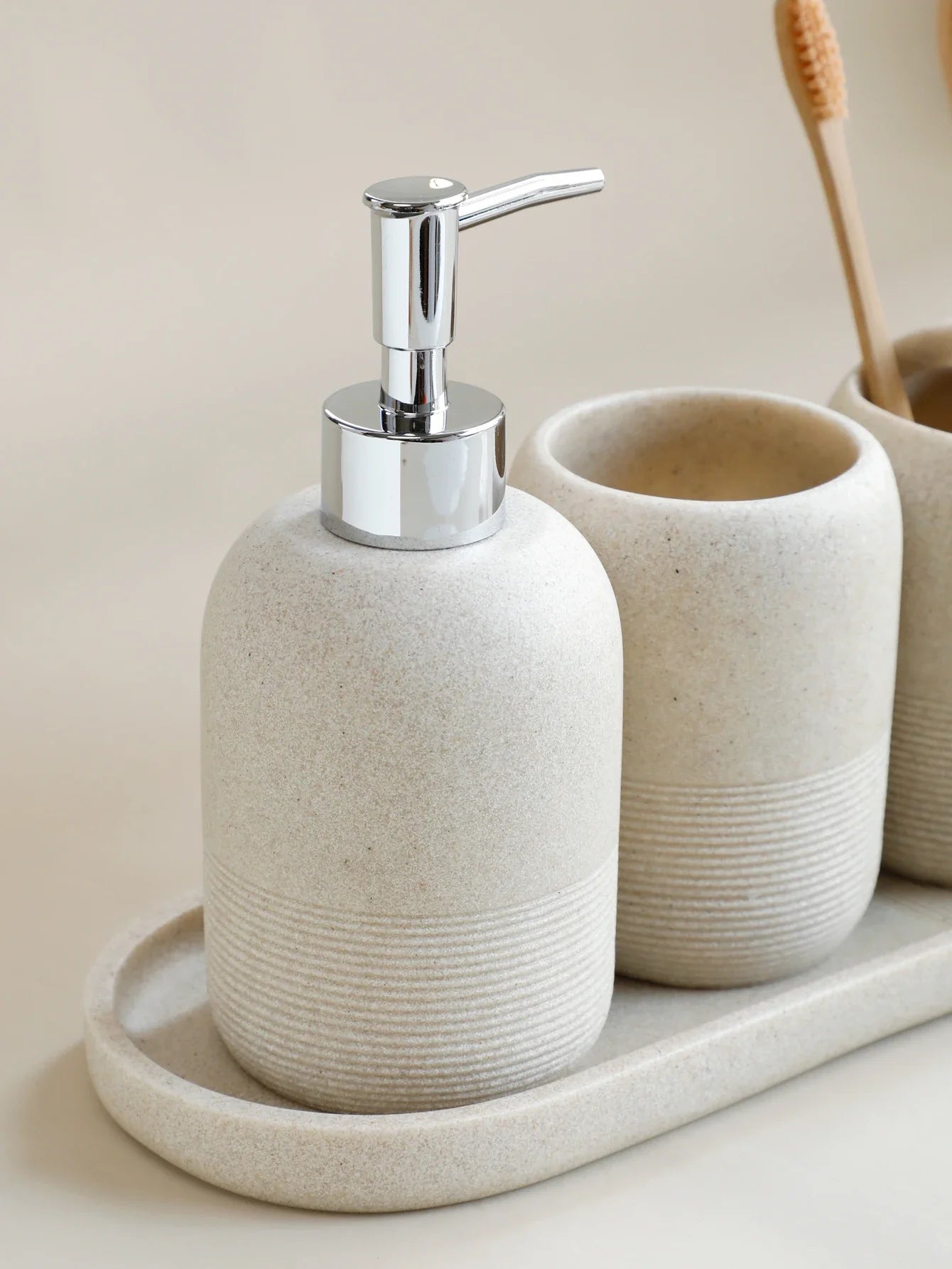 Minimalist ceramic bathroom accessory set with soap dispenser, toothbrush holder, and soap dish for modern home decor