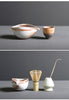 Minimalist Japanese matcha set with black ceramic tea bowl, bamboo whisk, whisk holder, and bamboo tea scoop for authentic tea ceremony