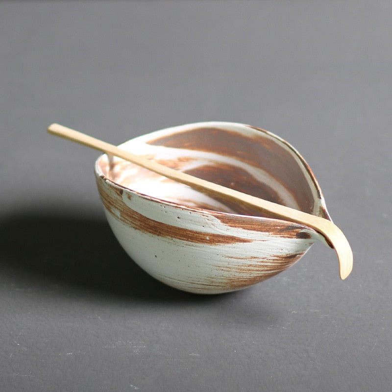 Minimalist Japanese matcha set with black ceramic tea bowl, bamboo whisk, whisk holder, and bamboo tea scoop for authentic tea ceremony