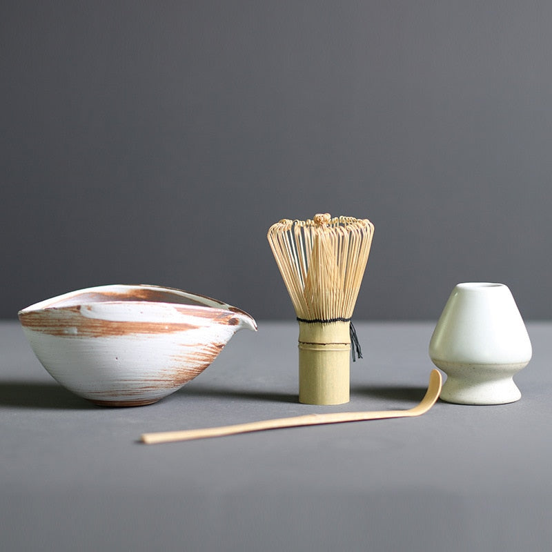 Minimalist Japanese matcha set with black ceramic tea bowl, bamboo whisk, whisk holder, and bamboo tea scoop for authentic tea ceremony