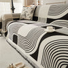 Modern geometric grey and white sofa cover with abstract wave pattern and fringe edges – washable couch slipcover for living room furniture protection