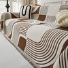 Modern geometric grey and white sofa cover with abstract wave pattern and fringe edges – washable couch slipcover for living room furniture protection