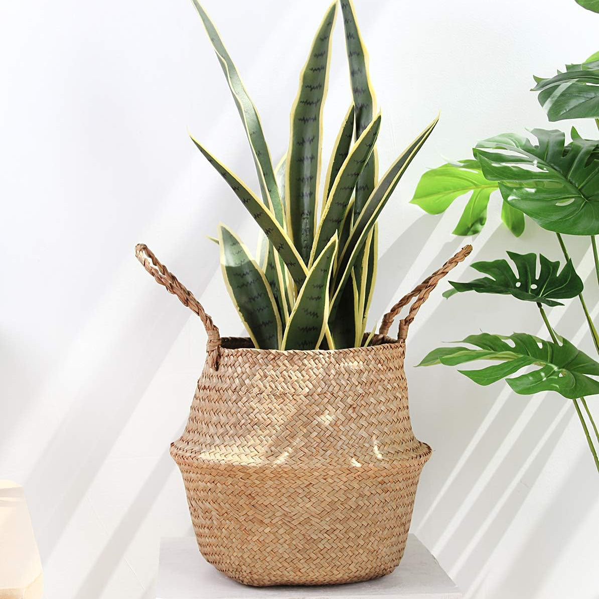 Handwoven seagrass storage baskets with pink and red roses, rustic woven planters for home decoration