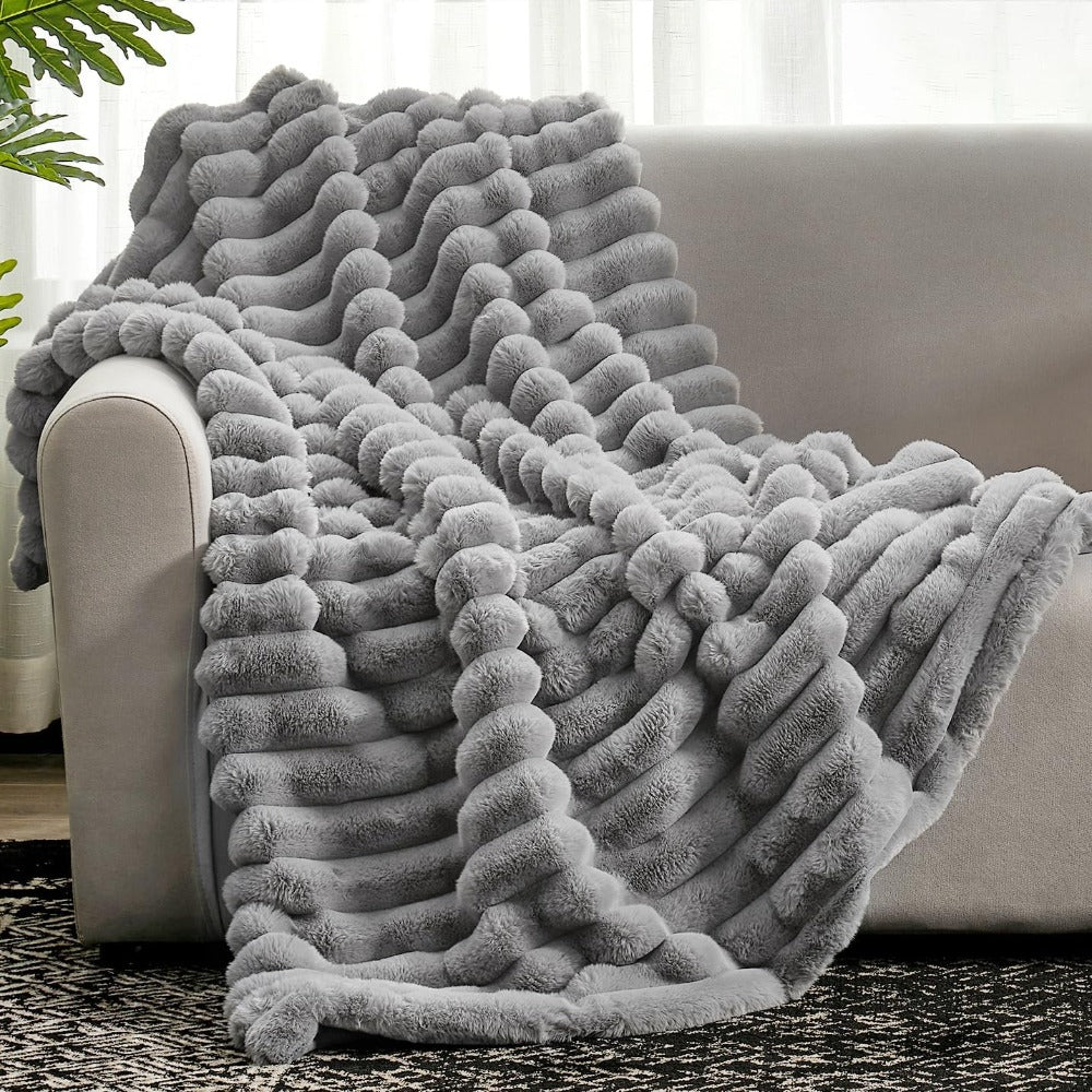 Plush grey faux fur throw blanket with ribbed texture, soft and warm decorative couch or bed cover