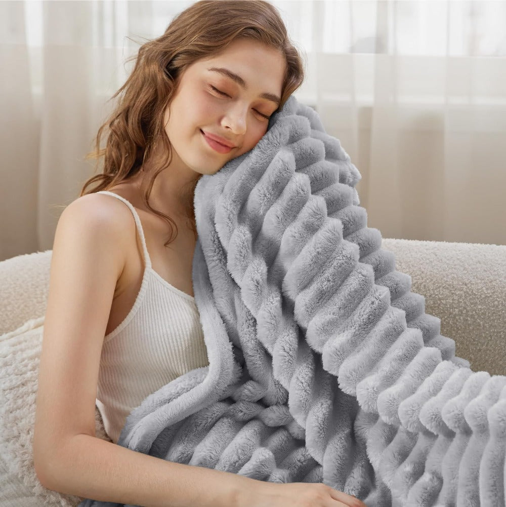 Plush grey faux fur throw blanket with ribbed texture, soft and warm decorative couch or bed cover