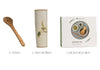 Japanese matcha set with white ceramic tea bowl and pink cherry blossom design, bamboo whisk, sifter, and tea scoop for traditional tea ceremony
